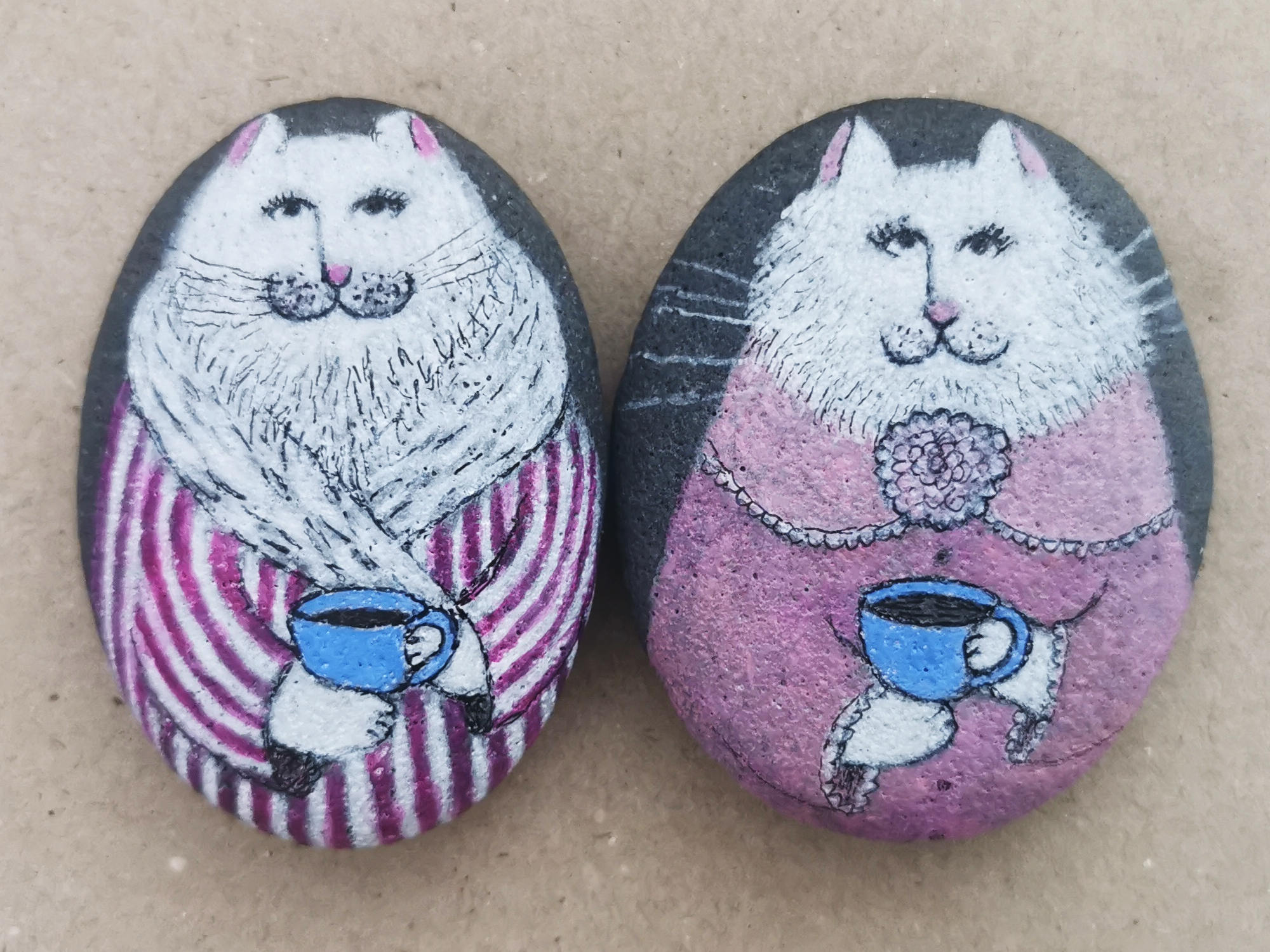 two cats drawings on stones