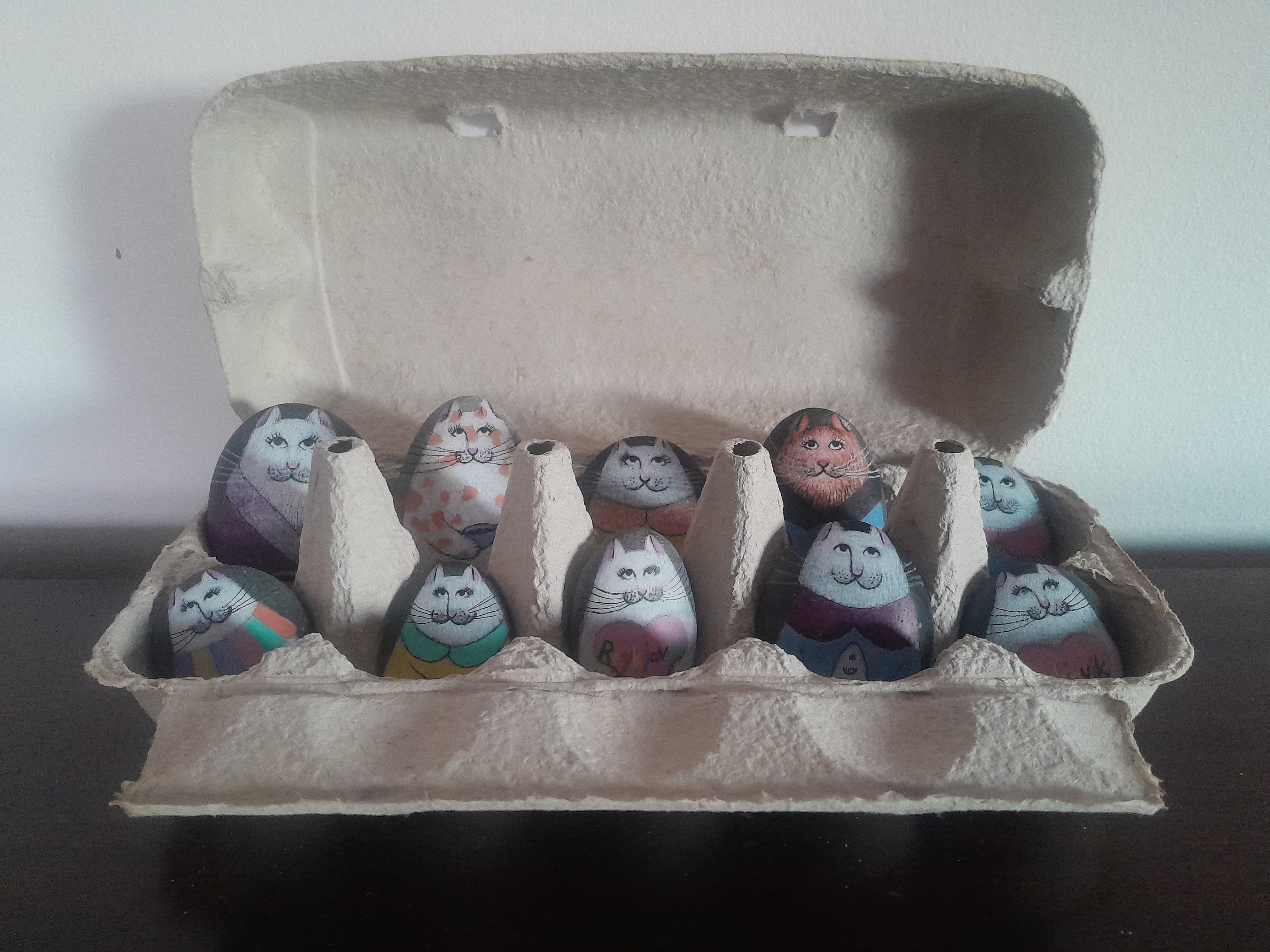 Painted stones sitting in an egg tray