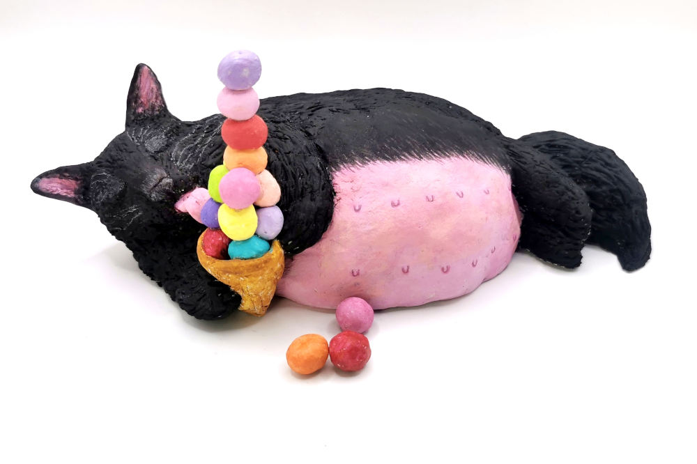 Fat black cat enjoying icecream